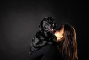 Ein Mädchen hält einen Labrador-Retriever-Hund in den Armen. foto