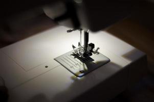 die frau näht mit nähmaschine. Nähen ist eine der ältesten Textilkünste. foto