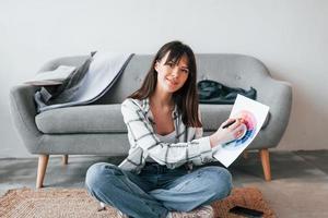 sitzt auf dem Boden. junge freiberufliche arbeiterin ist tagsüber zu hause foto