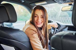 Fahrzeuginnenraum. frau sitzt in einem modernen schwarzen auto foto