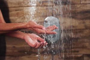 Nahaufnahme der Hände einer Frau, die im Spa duscht foto