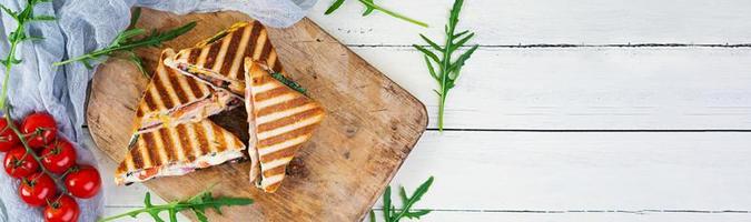 Sandwich mit Schinken, Käse, Senfblättern, Tomaten und Zwiebeln. leckere Sandwiches vom Grill foto