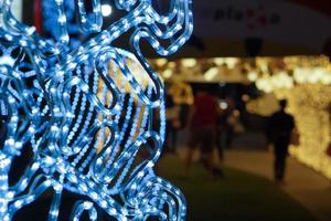 Nahaufnahme und Ernte verzierte LED von weihnachtlicher blauer Beleuchtung in Schneeflockenform auf verschwommenem Hintergrund. foto