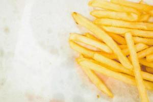 Draufsicht auf Pommes Frites auf weißem Papier mit Fleckenhintergrund. foto