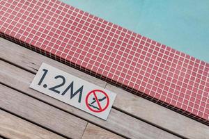 Schild mit 1,2 Meter Tiefe am Rand des blauen Swimmingpools ohne Tauchen. foto