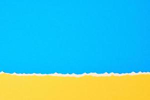 zerrissene zerrissene papierkante mit kopierraum, farbe blau und gelber hintergrund foto