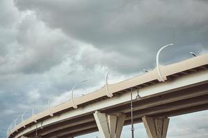 Teil der modernen Brücke mit Straßenbeleuchtung gegen bewölkten Himmel. foto