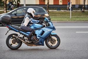 motorradfahrer, der fahrrad in der stadtstraße fährt foto