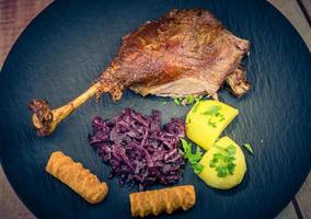 Gänsebraten mit Kartoffeln, Rotkohl und brauner Soße foto