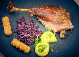 Gänsebraten mit Kartoffeln, Rotkohl und brauner Soße foto