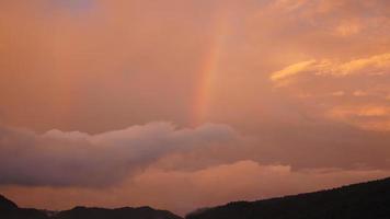 der bunte regenbogen, der nach dem sommerregen in den himmel aufsteigt foto