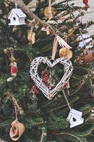 weihnachtsbaum geschmückt mit herzförmigem gewebtem kranz und anderen handgefertigten weihnachtsschmuckstücken ohne abfall foto