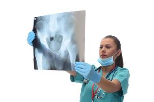 junger weiblicher arztchirurg, der patientenröntgenstrahl hält. isoliert auf weißem Hintergrund foto