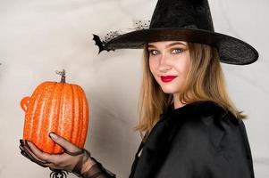 Nahaufnahmehalloween-Porträt der Hexe, die ganz in Schwarz gekleidet ist, mit roten Lippen, die sich darauf vorbereiten, Zauber zu setzen. 31. Oktober Trick-Ot-Treat-Party foto