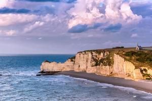 Malerischer Blick auf die Klippen von Etretat gegen bewölkten Himmel in der Normandie, Frankreich foto