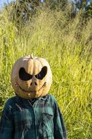 junge Frau mit Kürbiskopf nach dem Abschneiden und Aufsetzen eines Gesichts, Halloween, foto