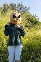 junge Frau mit Kürbiskopf nach dem Abschneiden und Aufsetzen eines Gesichts, Halloween, foto