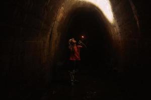 Baggerin mit Taschenlampe erkundet den Tunnel foto