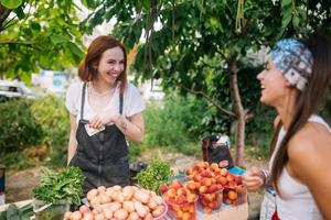 Verkäuferin bietet Bauernmarkt für frisches und biologisches Gemüse an. foto