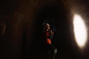 Baggerin mit Taschenlampe erkundet den Tunnel foto