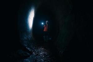 Baggerin mit Taschenlampe erkundet den Tunnel foto