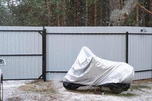 Motorradaufbewahrung unter einer Markise im Winter im Freien. schützende Markise, unter dem Schnee foto