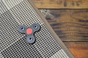 beliebtes Fingerspinner-Gerät. modernes Fidget-Spinnspielzeug auf Lagern. Drehen Sie es in den Händen, lernen Sie coole neue Tricks. Viel Spaß mit diesem neuen rotierenden Gadget foto