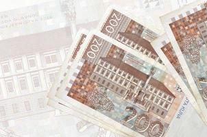 200 kroatische Kuna-Scheine liegen im Stapel auf dem Hintergrund einer großen halbtransparenten Banknote. abstrakte Darstellung der Landeswährung foto