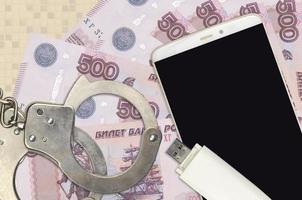 500 russische Rubel-Scheine und Smartphone mit Polizeihandschellen. Konzept von Hacker-Phishing-Angriffen, illegalem Betrug oder weicher Verteilung von Malware foto