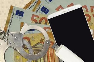 50-Euro-Scheine und Smartphone mit Polizeihandschellen. Konzept von Hacker-Phishing-Angriffen, illegalem Betrug oder weicher Verteilung von Malware foto