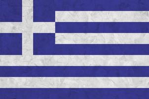 griechische flagge in hellen farben auf alter reliefputzwand dargestellt. strukturierte Fahne auf rauem Hintergrund foto