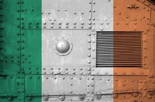 irland-flagge auf seitenteil des militärischen gepanzerten panzers in der nähe abgebildet. konzeptioneller hintergrund der armee foto