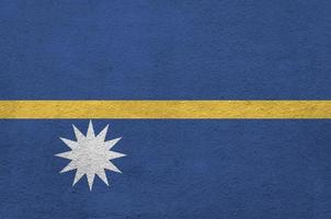 nauru-flagge in hellen farben auf alter reliefputzwand dargestellt. strukturierte Fahne auf rauem Hintergrund foto