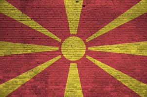 Mazedonien-Flagge in Lackfarben auf alter Backsteinmauer dargestellt. strukturiertes banner auf großem backsteinmauermauerwerkhintergrund foto