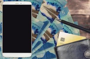 5 kanadische Dollar-Scheine und Smartphone mit Geldbörse und Kreditkarte. E-Payments oder E-Commerce-Konzept. Online-Shopping und Geschäfte mit tragbaren Geräten foto