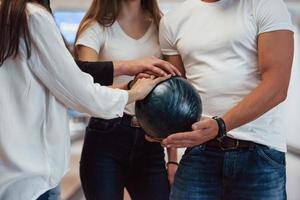 Lass uns das Spiel beginnen. Beschnittene Ansicht von Leuten im Bowlingclub, die bereit sind, Spaß zu haben foto