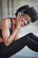 Porträt eines afroamerikanischen Mädchens in Fitnesskleidung, das nach dem Training eine Pause macht foto