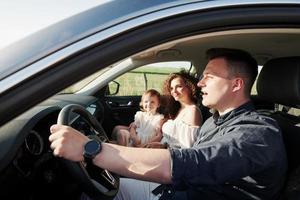 unterwegs. Schöne Menschen sitzen an ihren Wochenenden im modernen Auto foto