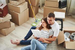 Dokument lesen. fröhliches junges Paar in ihrer neuen Wohnung. Vorstellung von Bewegung foto