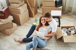 Dokument lesen. fröhliches junges Paar in ihrer neuen Wohnung. Vorstellung von Bewegung foto