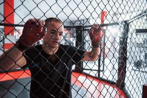 eine Pause machen. sportler am boxring haben übung. an den Zaun gelehnt foto