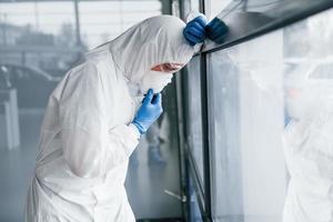 männlicher arztwissenschaftler in laborkittel, defensiver brille und maske fühlt sich schlecht, erschöpft und krank an foto