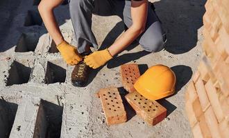 Nahaufnahme des Bauarbeiters in Uniform und Sicherheitsausrüstung, die sich auf den Job vorbereiten foto