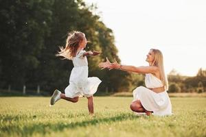 wahre Liebe. mutter und tochter genießen das gemeinsame wochenende, indem sie draußen auf dem feld spazieren gehen. schöne Natur foto