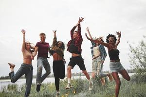 leichte Sommerkleidung. gruppe von menschen picknickt am strand. Freunde haben Spaß am Wochenende foto