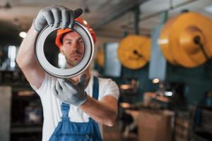 sieht gut aus. Mann in Uniform arbeitet an der Produktion. Industrielle moderne Technologie foto