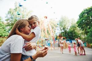 Eis essen. Fröhliches kleines Mädchen, ihre Mutter, hat eine gute Zeit im Park zusammen in der Nähe von Sehenswürdigkeiten foto