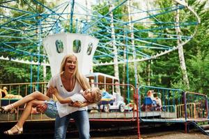 Fröhliches kleines Mädchen, ihre Mutter, hat eine gute Zeit im Park zusammen in der Nähe von Sehenswürdigkeiten foto