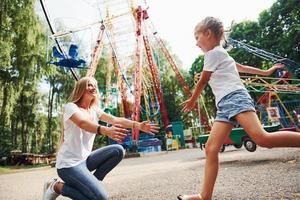 laufen und spielen. Fröhliches kleines Mädchen, ihre Mutter, hat eine gute Zeit im Park zusammen in der Nähe von Sehenswürdigkeiten foto