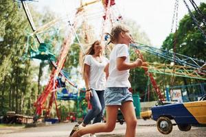 laufen und spielen. Fröhliches kleines Mädchen, ihre Mutter, hat eine gute Zeit im Park zusammen in der Nähe von Sehenswürdigkeiten foto